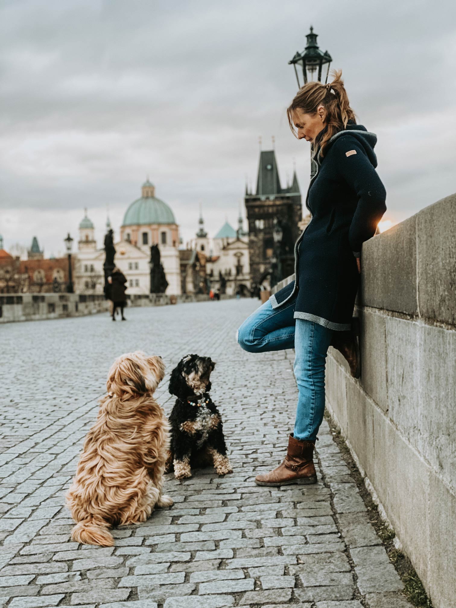 Hundehalterin mit Tibetterrier und Cockapoo auf der Karlsbrücke in Prag