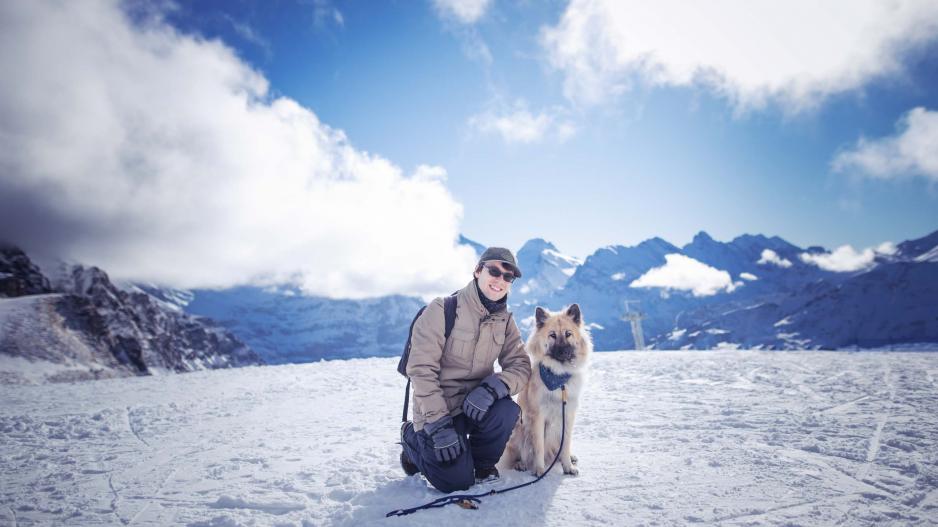 Mann mit Eurasier im Schnee